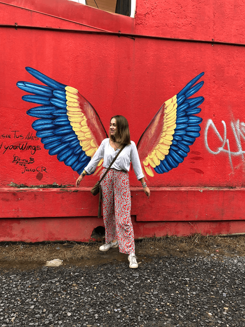 Schülerin vor einer Wandmalerei in San José, Sinnbild für Kultur und Alltag während eines Schuljahres im Ausland in Costa Rica.